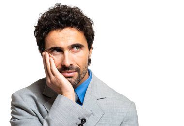 Beyaz arka planda izole edilmiş dalgın genç bir iş adamına yakın plan 