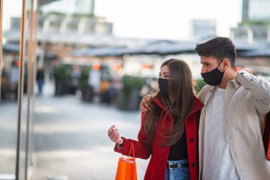 Covid ve Coronavirus alışverişi, alışveriş torbaları taşıyan genç bir çift.