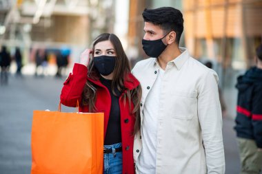 Covid ve Coronavirus alışverişi, alışveriş torbaları taşıyan genç bir çift.