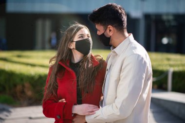 Coronavirüs salgını sırasında şehirde yürüyen ve eğlenen bir çift.