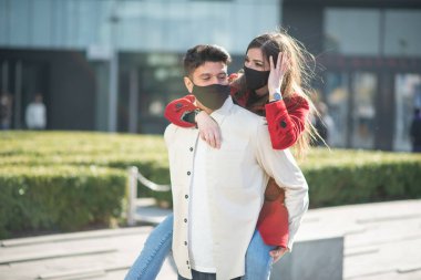 Coronavirus salgını sırasında kadınını taşıyan ve eğlenen bir adam.