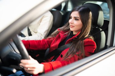 Arabasını süren gülümseyen genç kadın.