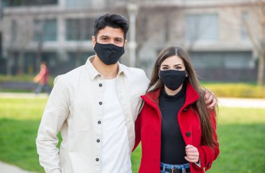 Coronavirüs salgını sırasında şehirde yürüyen ve eğlenen bir çift.