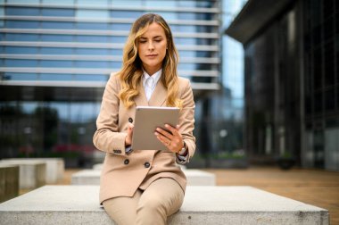 Gülümseyen iş kadını dijital tablet kullanıyor.
