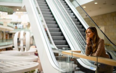 Düşünceli bir iş kadını. Düşünceli bir ifadeyle, parlak bir alışveriş merkezinde.