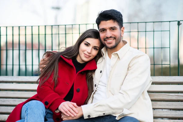 Mutlu çift bankta oturmuş gülümsüyor.