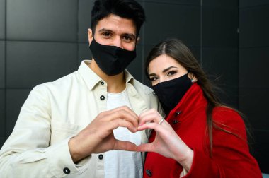 Çift maske takıyor ve kalp işareti yapıyor, covid ve coronavirus konsepti