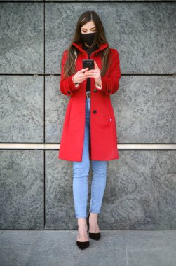 Koronavirüs covid 19 salgınına karşı koruyucu maske takan bir kadın. Tam boy portre.