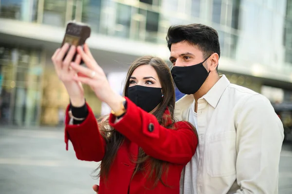若いですカップル取りますA自撮り肖像画一緒に屋外とマスクを身に着けていますコロナウイルスCovid 19パンデミックを防ぐために — ストック写真
