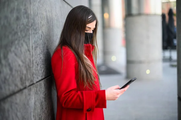 Kvinna Som Använder Sin Smartphone Medan Hon Bär Skyddande Mask — Stockfoto