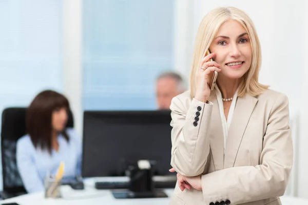 Sorridente Empresária Falando Telefone Com Dois Colegas Segundo Plano — Fotografia de Stock