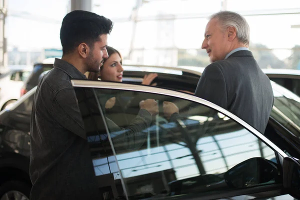 Jonge Familie Praat Met Verkoper Kiest Een Nieuwe Auto Een — Stockfoto