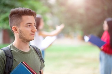 Okulun, üniversitenin ya da üniversitenin yakınındaki bir grup arkadaşın önünde genç bir öğrenci