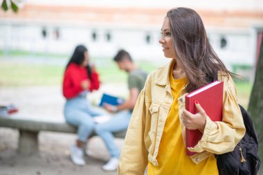 Parkta gülümseyen mutlu bir öğrenci