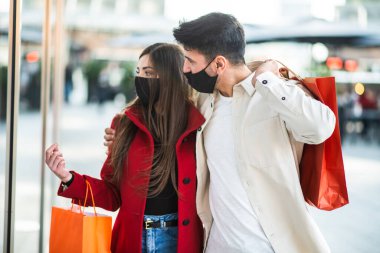 Covid ve Coronavirus alışverişi, alışveriş torbaları taşıyan genç bir çift.