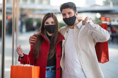 Covid ve Coronavirus alışverişi, alışveriş torbaları taşıyan genç bir çift.