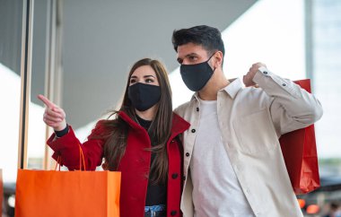 Covid ve Coronavirus alışverişi, alışveriş torbaları taşıyan genç bir çift.