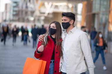 Covid ve Coronavirus alışverişi, alışveriş torbaları taşıyan genç bir çift.