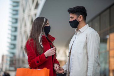 Covid ve Coronavirus alışverişi, alışveriş çantası taşıyan genç bir çift.