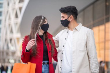 Covid ve Coronavirus alışverişi, alışveriş çantası taşıyan genç bir çift.