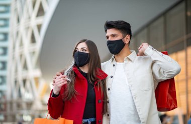 Covid ve Coronavirus alışverişi, alışveriş torbaları taşıyan genç bir çift.