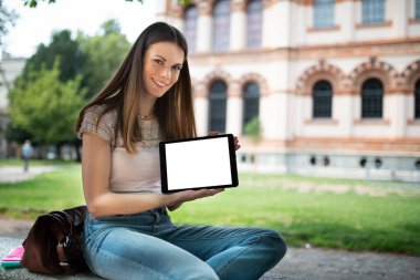 Genç mutlu kadın boş bir tablet ekranı gösteriyor