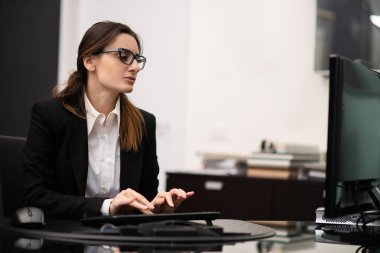 Modern ofisinde bilgisayar kullanan bir iş kadını.