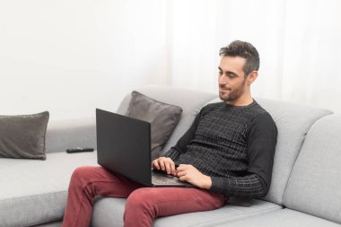 Evdeki bilgisayarı üzerinde çalışan adam, akıllı çalışma konsepti.