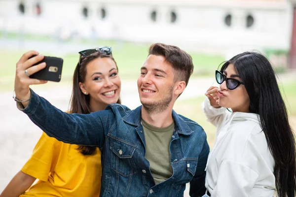 Wesoły Uśmiech Przyjaciół Parku Siedzi Ławce Robi Selfie Pomocą Smartfona — Zdjęcie stockowe