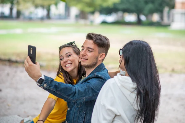 Amigos Sorridentes Alegres Parque Sentado Banco Tirando Selfies Usando Telefone — Fotografia de Stock