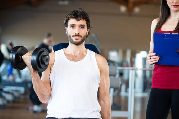 Hombre Haciendo Ejercicio Gimnasio Mientras Entrenador Personal Mira Ejecución —  Fotos de Stock