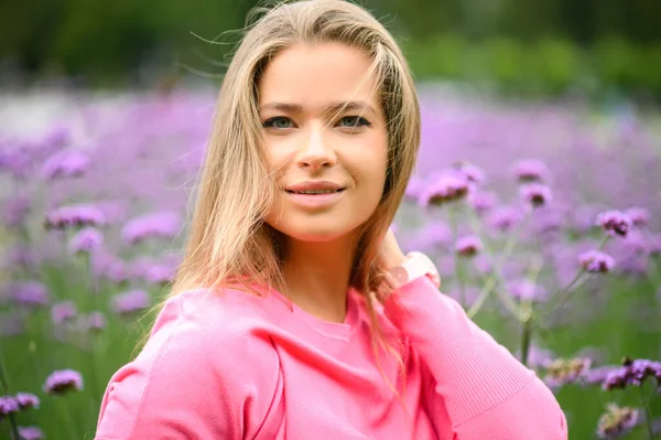 Młoda Kobieta Portret Pozowanie Przeciwko Purpurowe Kwiaty — Zdjęcie stockowe