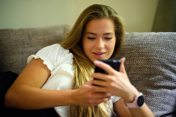 Jeune Femme Utilisant Son Smartphone Sur Son Canapé — Photo