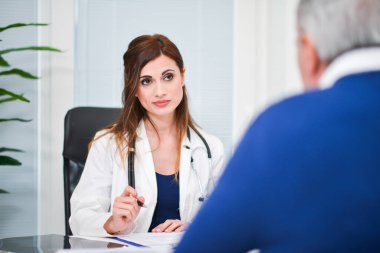 Doktor ziyaretinde hastasıyla konuşuyor.