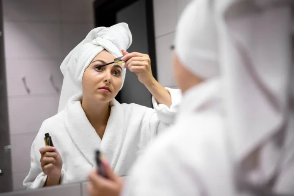 Sorrindo Menina Bonita Roupão Banho Aplicando Maquiagem Espelho — Fotografia de Stock