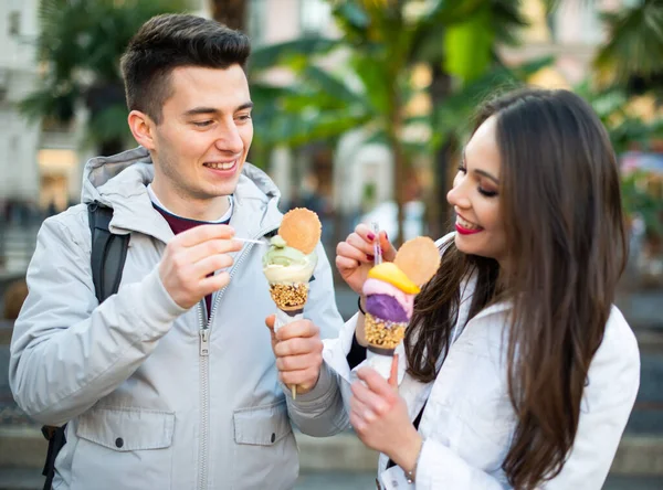 幸せなカップルが街の屋外でアイスクリームを食べる — ストック写真
