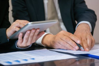 Toplantı sırasında tablet kullanan iş adamları