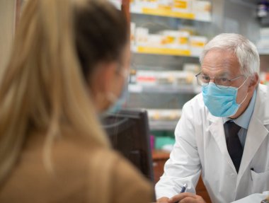 Genç maskeli kadın eczaneye giriş yapıyor. Coronavirus konsepti.