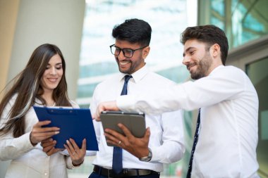 Ofislerinde tablet kullanan bir grup iş adamı, takım çalışması konsepti