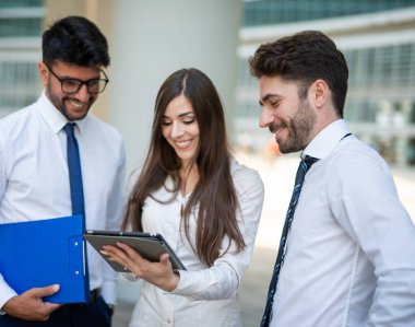 Ofislerinde tablet kullanan bir grup iş adamı, takım çalışması konsepti