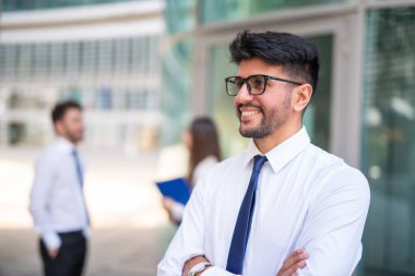 Bir grup meslektaşın önünde gülümseyen iş adamı, takım çalışması konsepti