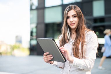 Gülümseyen iş kadını dijital tablet kullanıyor.