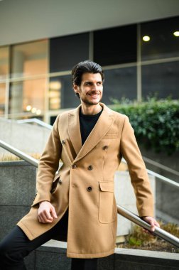 Modern bir şehirde merdivenleri çıkan yakışıklı, zarif bir adam.