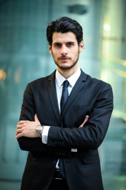Genç işadamı kendine güvenerek gülümsüyor.