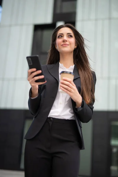 女商人在一个现代化的城市广场用她的智能手机 — 图库照片