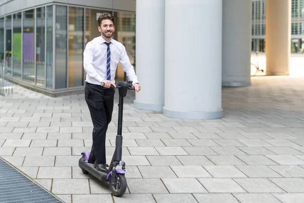 Businessman using his electric scooter in a city