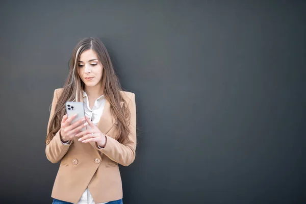 Mujer Negocios Pie Contra Una Pizarra Pared Negra Con Teléfono —  Fotos de Stock