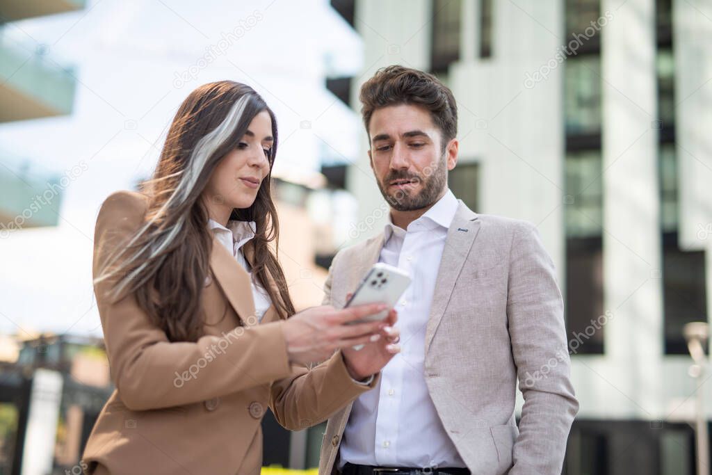 Young businesswoman showing her smartphone to a colleague