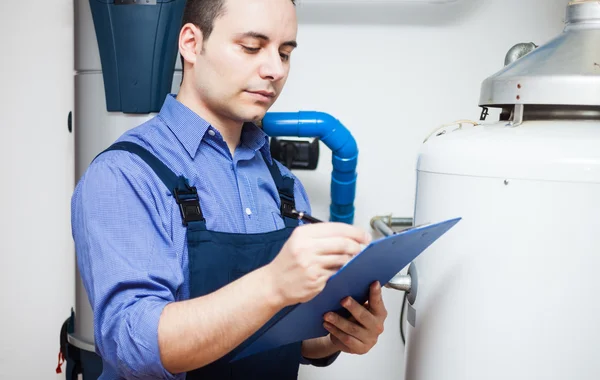 Técnico de mantenimiento de un calentador de agua caliente — Foto de Stock