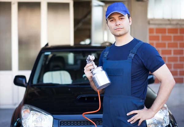 Bil kropp reparatör håller sprutpistol — Stockfoto